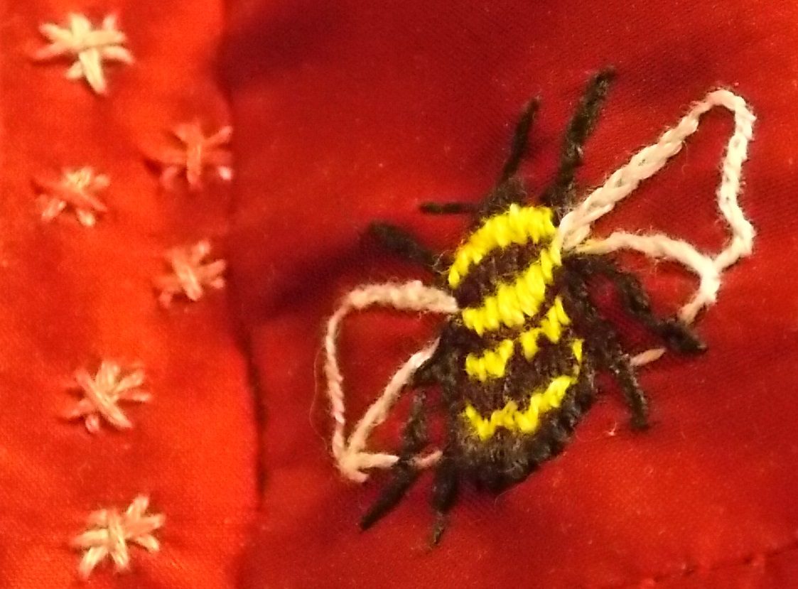 embroidered bee on the red dress